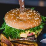 Cuisine - Burger With Fried Fries on Black Plate With Sauce on the side