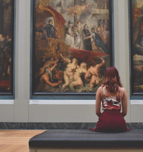 Museums - Woman Sitting on Ottoman in Front of Three Paintings