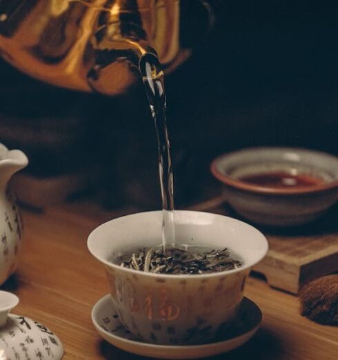 Tea Ceremony - Gold Kettle Pouring Hot Water on Cup of Tea