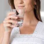 Drink Water - Woman in White Floral Lace Sleeveless Dress Holding Clear Drinking Glass