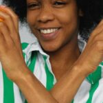 Healthy Eating - Smiling Woman in White and Blue Stripe Shirt Holding Orange Fruits