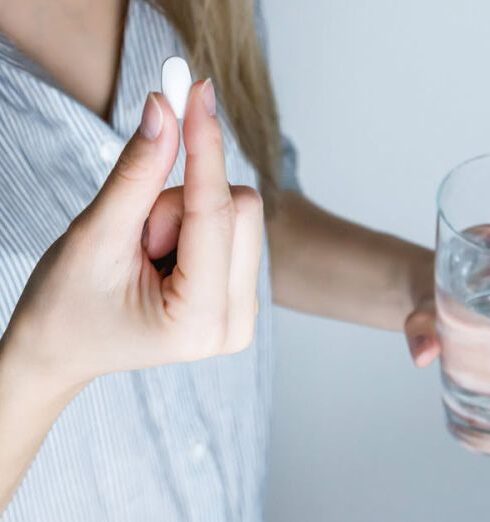 Drink Water - Woman Holding Half-full Glass and White Medicine Pill