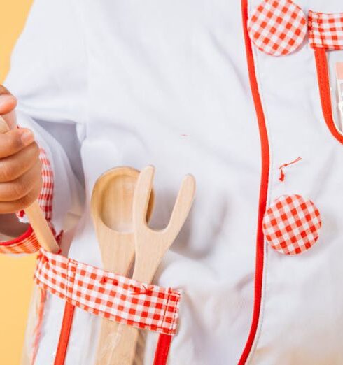 Chef Experience - Adorable African American child wearing uniform of cook standing with kitchen tools in studio