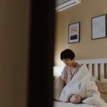 Loneliness - Woman Sitting on White Bed