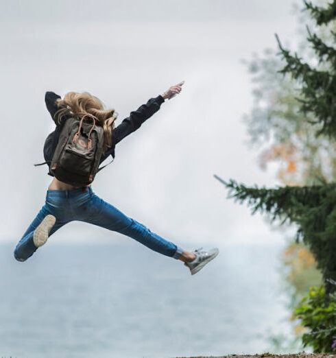 Backpacking - Woman Jumping Wearing Green Backpack