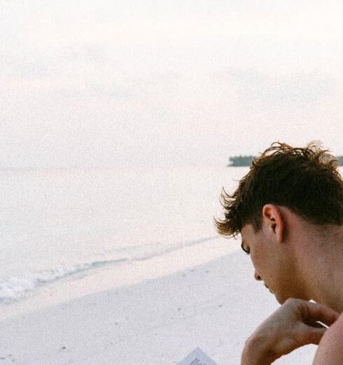 Books - Topless Man Reading Book While Seating at Beach