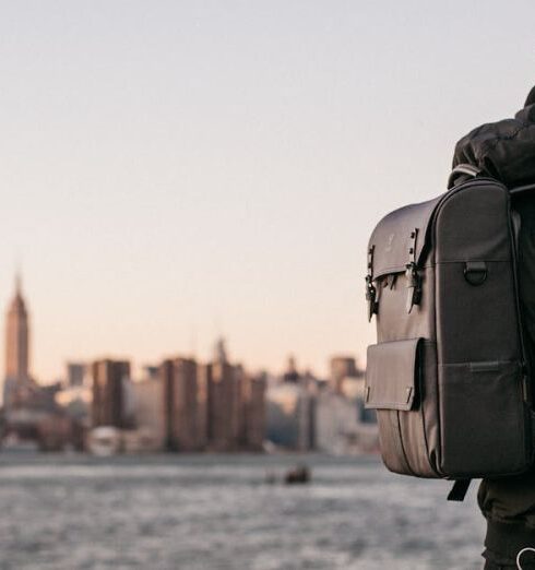 Backpack - Man Wearing Black Bubble Jacket and Black Leather Backpack Near Bay