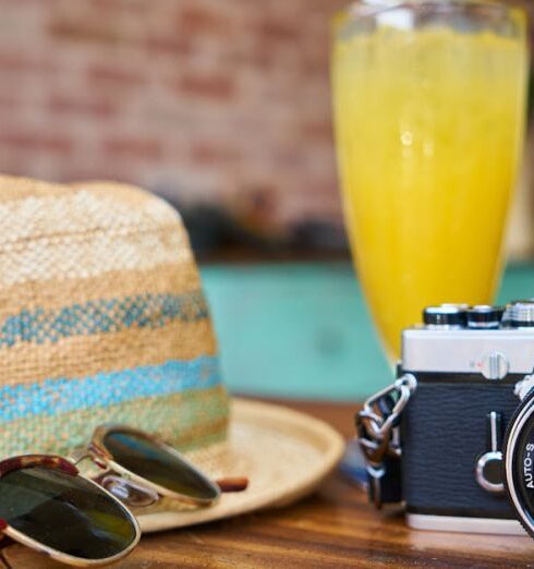 Vacation - Gray and Black Dslr Camera Beside Sun Hat and Sunglasses