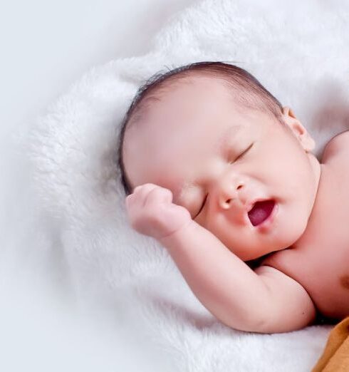 Baby - Baby Lying On White Fur With Brown Blanket