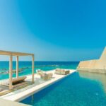 All-Inclusive Resorts - Architectural Photography of Gray Granite Swimming Pool and Outdoor Lounge at Beach Side