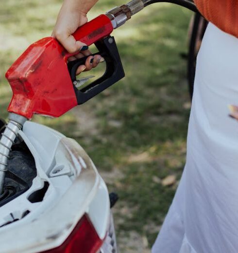 Gas Stations - A Person in White Skirt Filling Up a Motorcycle with Gas