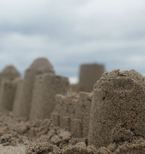 Sandcastle - Person Standing Near Sand Castle