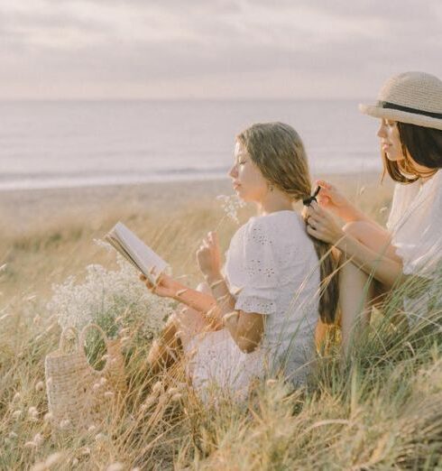 Beach Reads - Man and Woman Sitting on Grass Field