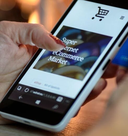 Shopping - Person Using Black And White Smartphone and Holding Blue Card