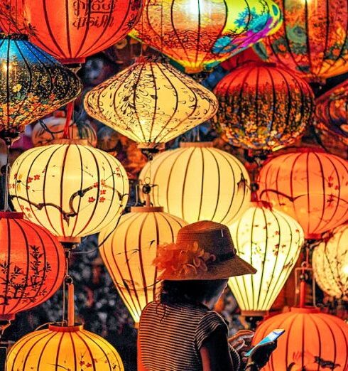 Culture - Two Person Standing Near Assorted-color Paper Lanterns