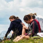 Digital Detox - Hikers Relaxing in Scenic Mountainous Meadow