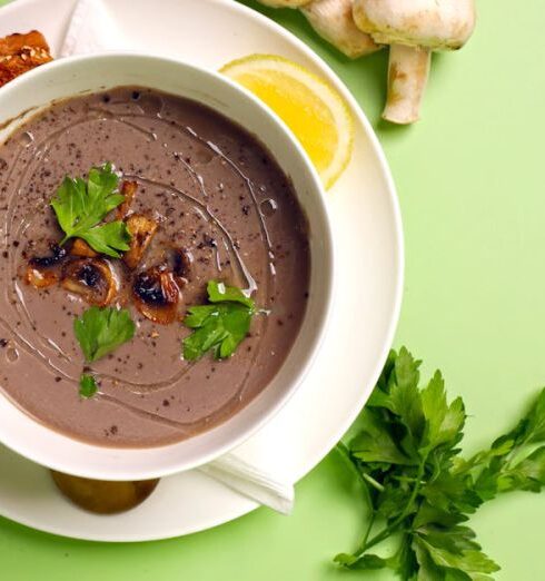 Meal Prep - A bowl of soup with mushrooms and bread on a green background