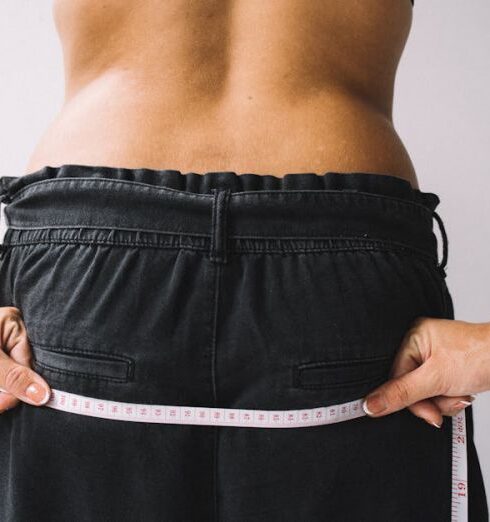 Wellness Journal - A Close-Up Shot of a Person Holding a Tape Measure