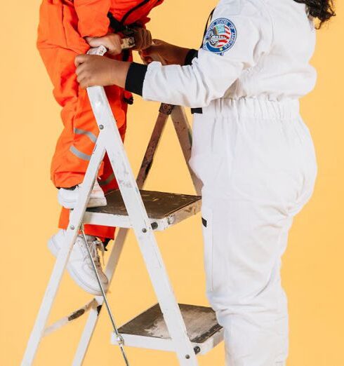 Activities - Content ethnic children in spacesuits standing on stepladder