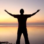 Solo - Silhouette of Man Standing Beside Ocean during Sunset