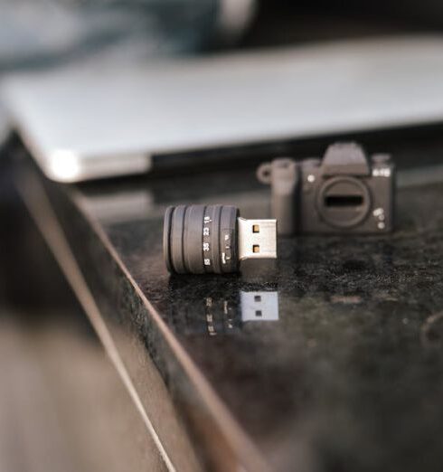 Adapter - Crop anonymous male sitting on stone bench with modern netbook and portable contemporary USB adapter