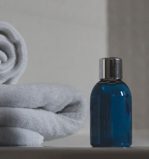 Toiletries - Blue Glass Bottle Beside White Towel