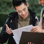 Anti-Theft Backpacks - Multiethnic students reading report in folder together