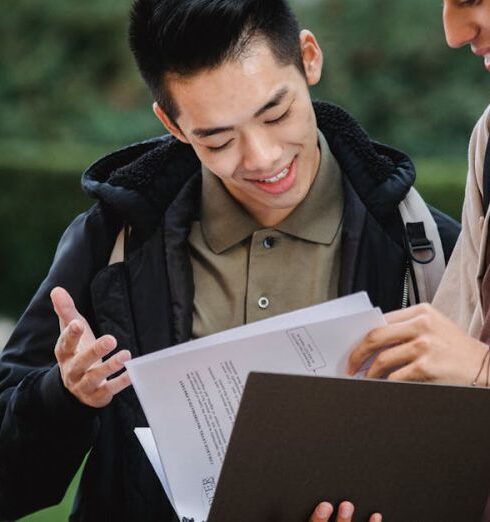 Anti-Theft Backpacks - Multiethnic students reading report in folder together