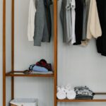 Packing Tips - Open Suitcase Lying in Front of a Clothes Rack