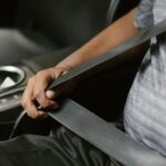 Travel Belt - From above of crop unrecognizable male driver fastening seat belt while sitting in car in daytime