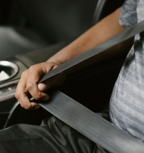 Travel Belt - From above of crop unrecognizable male driver fastening seat belt while sitting in car in daytime