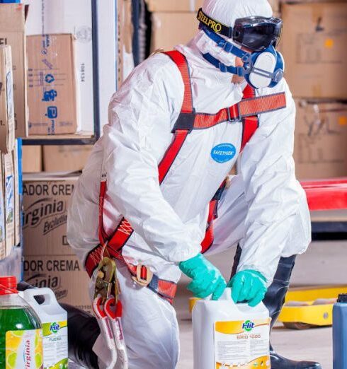 Safety - Person Wearing White Suit Holding White Container