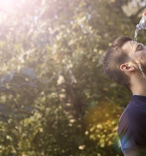 Hydration - Man in Blue Crew Neck T-shirt While Pouring Water on His Face