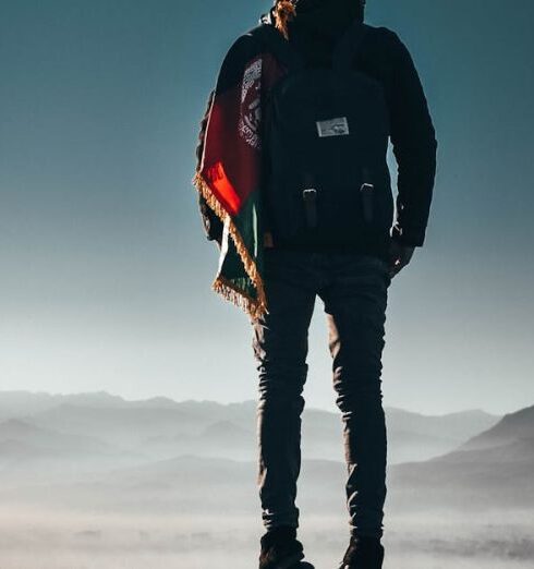 Adventure - Man Carrying Backpack Standing on Rock Formation