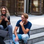 Students - Three Persons Sitting on the Stairs Talking With Each Other