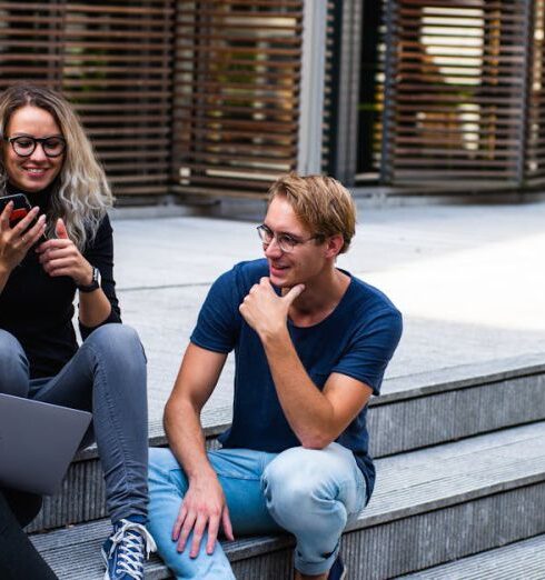 Students - Three Persons Sitting on the Stairs Talking With Each Other