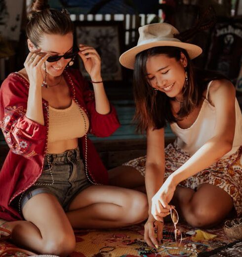 Souvenirs - Young Women Sitting on a Mat Having Fun Making Beads