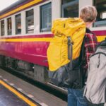 Backpackers - Woman and Man Waiting on Train Station