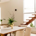 Accommodation - Interior of light living room with wooden stairs and table with comfortable chairs in contemporary house