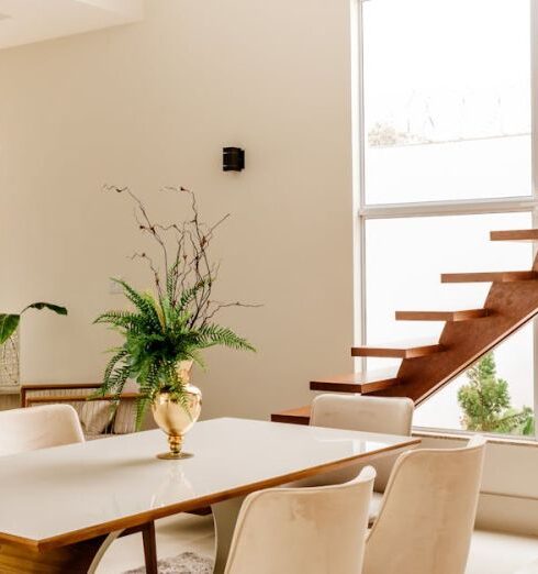 Accommodation - Interior of light living room with wooden stairs and table with comfortable chairs in contemporary house