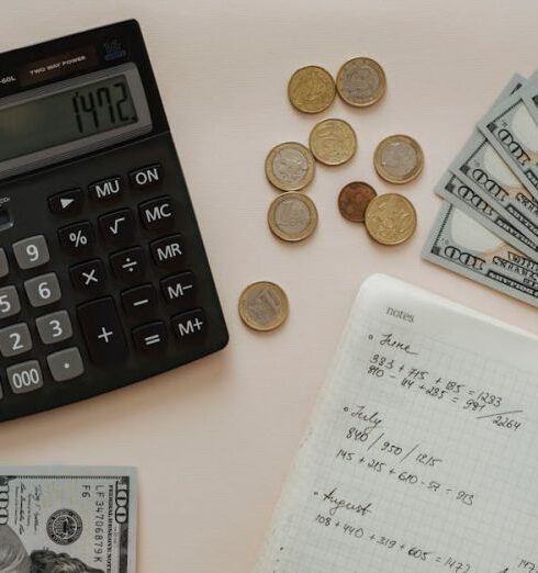 Expenses - Black Calculator beside Coins and Notebook