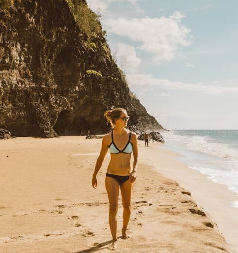 Destinations - Woman Walking along Beach