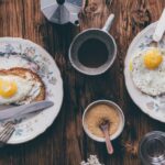 Meals - Breakfast Meals beside a Cup of Coffee on a Wooden Table