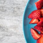 Diet - sliced strawberries on teal ceramic plate