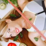 Vegetarianism - Woman Holding Tape Measure while Lying Among Healthy Food