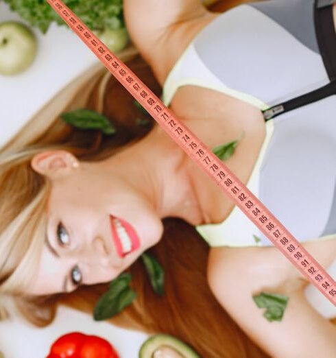 Vegetarianism - Woman Holding Tape Measure while Lying Among Healthy Food