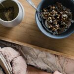 Muesli - Woman sitting on bed with breakfast on tray