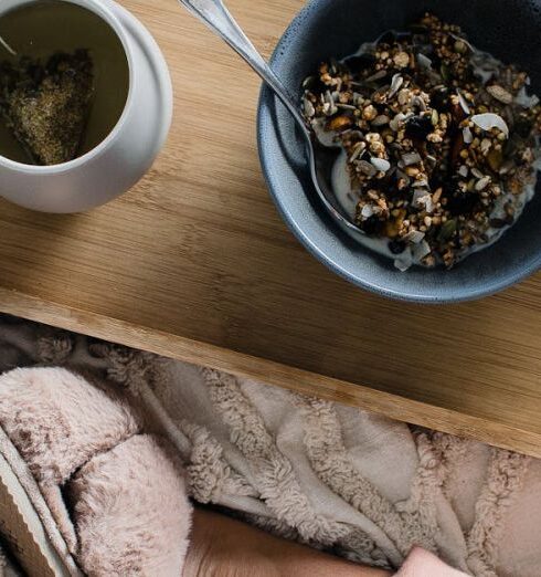 Muesli - Woman sitting on bed with breakfast on tray