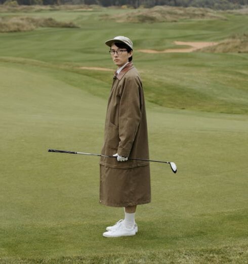 Tee - Man in Brown Robe Holding Golf Club on Green Grass Field