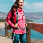 Windbreaker - Woman in Pink Zip Up Jacket and Blue Denim Jeans Standing on Brown Wooden Bridge during